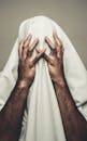 一个人身上盖着白布，双手抱头，显得神秘而压抑