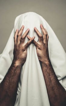 一个人身上盖着白布，双手抱头，显得神秘而压抑