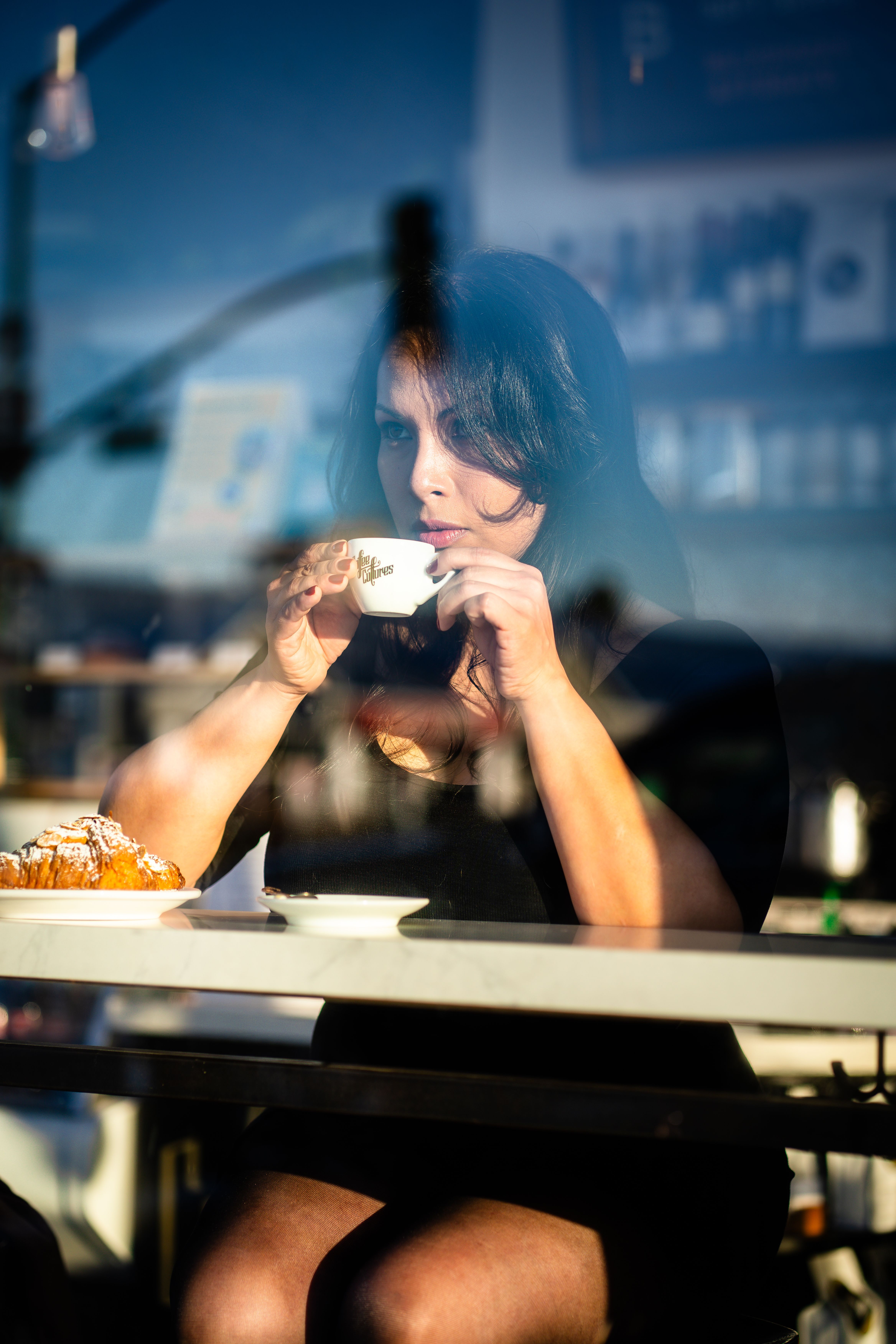 A woman sipping coffee in a cafe, reflecting a cozy and relaxing atmosphere.