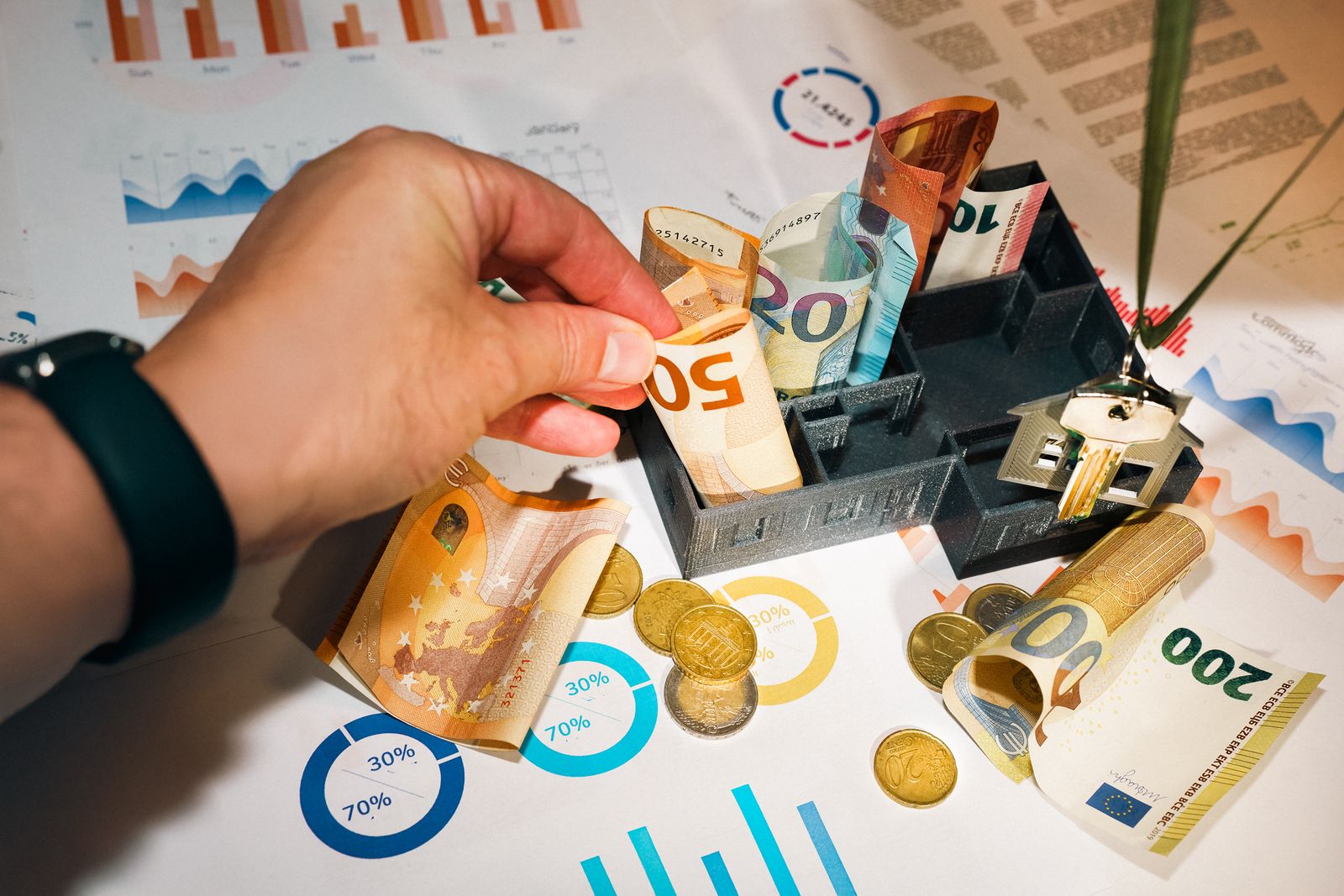Billetes y monedas de euro con gráficos para analizar estabilidad financiera