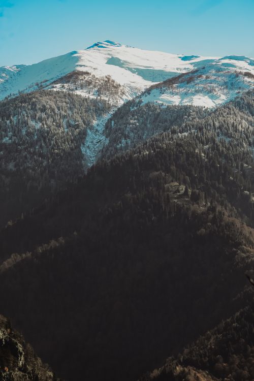 Free Breathtaking view of a snow-capped mountain range under a clear blue sky. Stock Photo