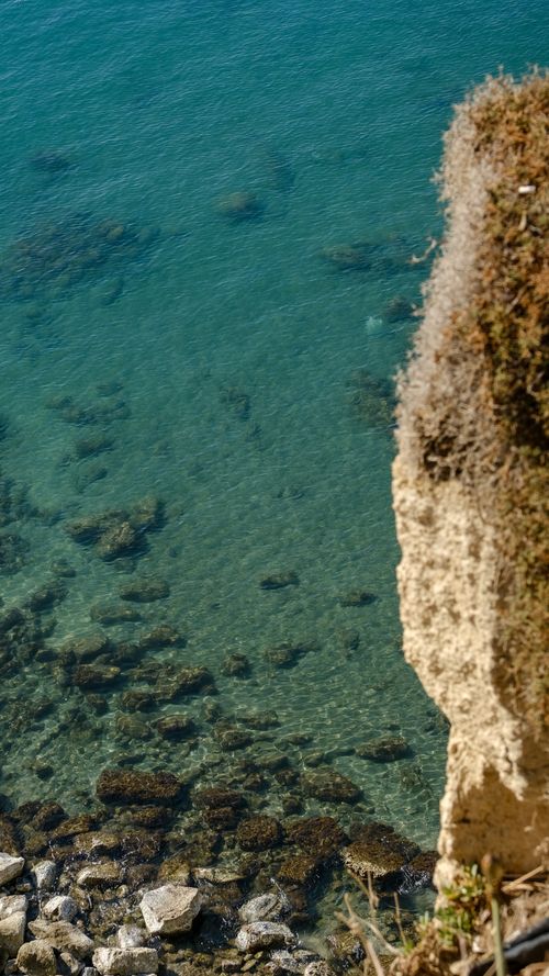 Free Stunning view of clear turquoise ocean water from a rocky cliffside. Stock Photo