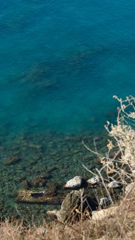 A stunning view of clear blue coastal waters and rocky shoreline. Perfect for serene landscapes.