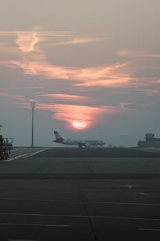 An airplane on the runway of Schwechat Airport, Austria, during a tranquil sunset.