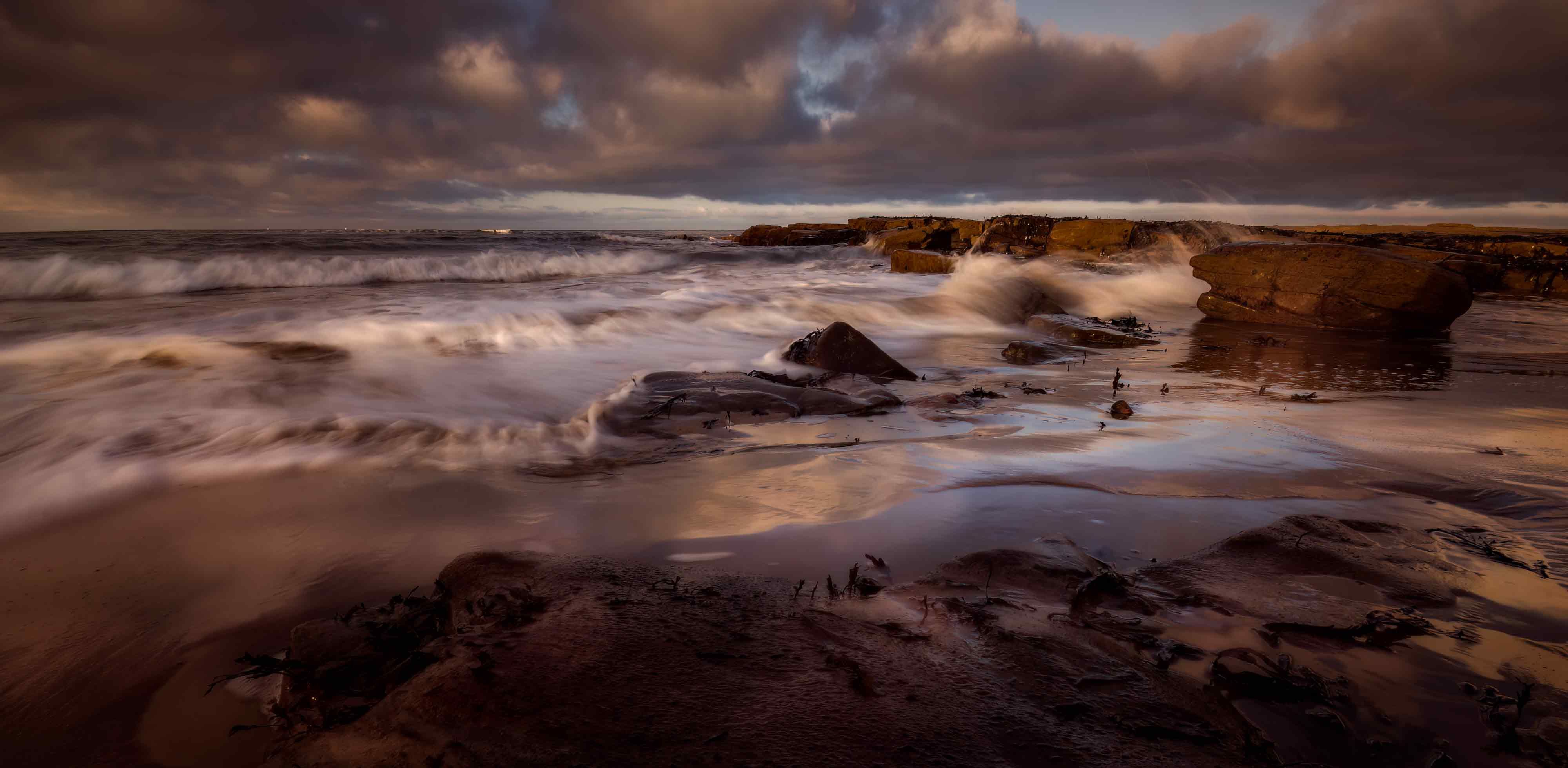 Dramatic Coastal Sunset with Waves on Rocky Beach · Free Stock Photo