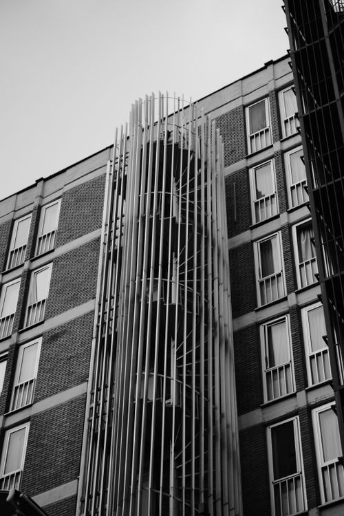 Free Striking geometric facade of a building featuring vertical lines and windows in monochrome. Stock Photo