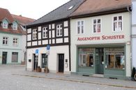 Charming optician shop with traditional European architecture in a quaint town setting.