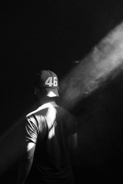 Black and white portrait of a man in a hat lit from behind — photo by Ali Pli on Pexels