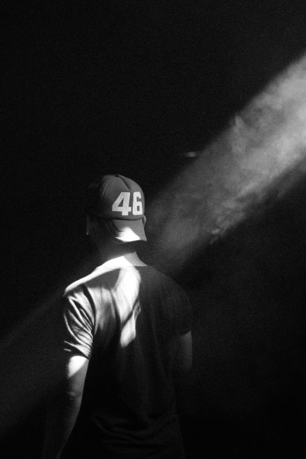Black and white portrait of a man in a hat lit from behind — photo by Ali Pli on Pexels