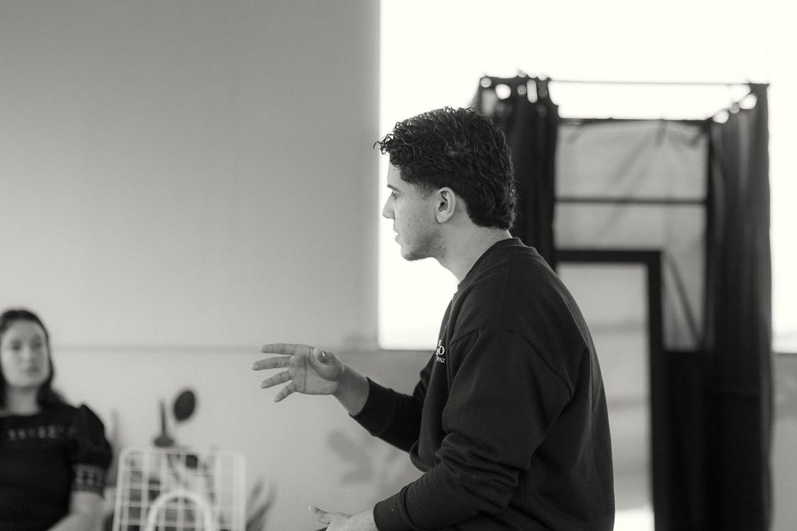 A black and white portrait capturing two individuals engaged in a thoughtful discussion, highlighting their expressions and emotions.