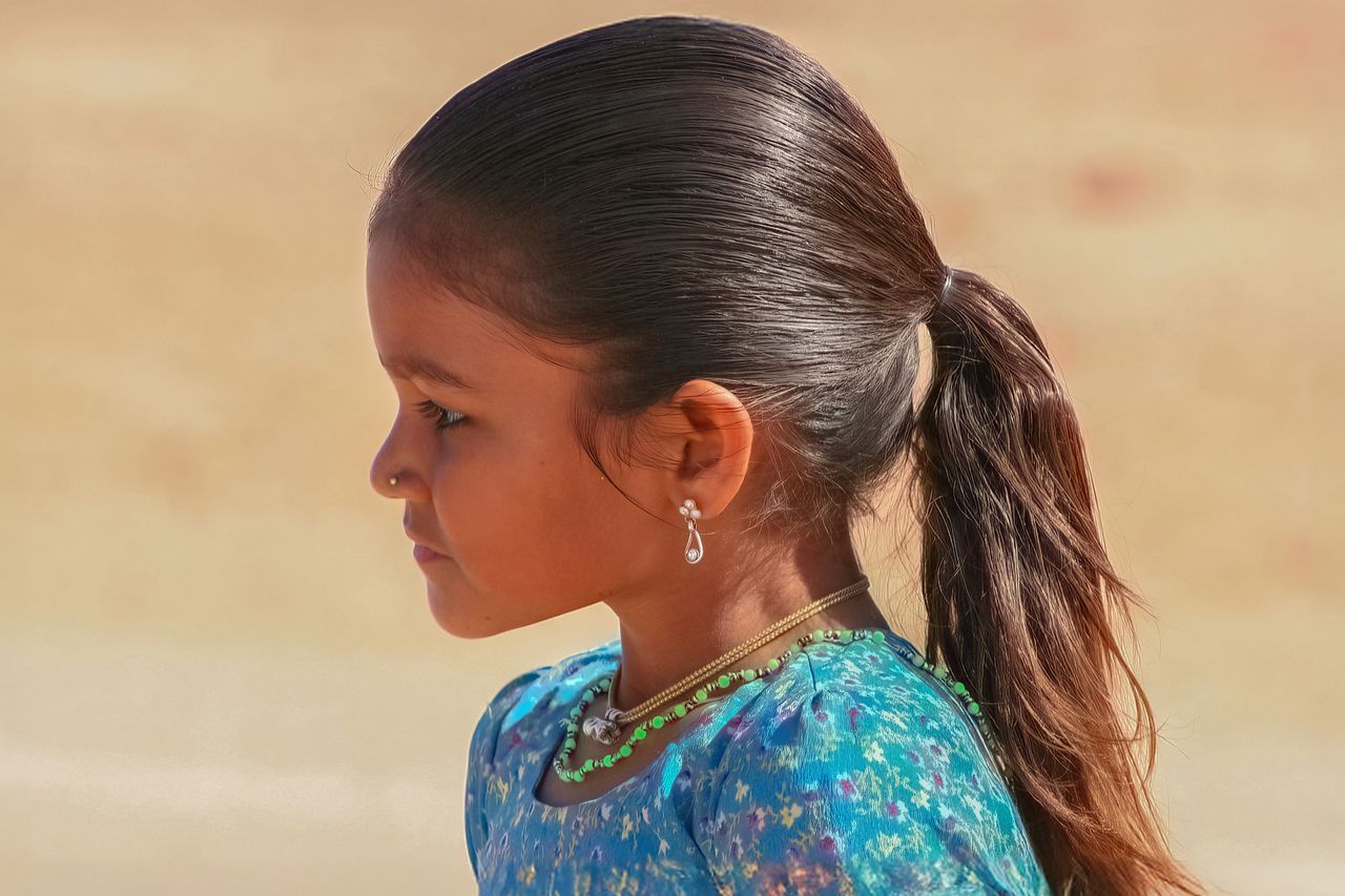 side profile of a girl in traditional attire with a soft background sh