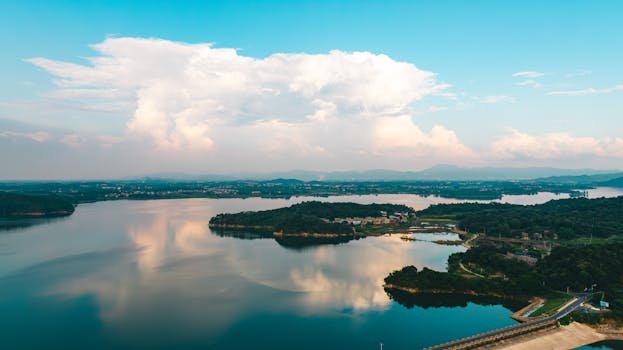 Aerial view of a calm lake with islands and surrounding landscape at twilight, showcasing a serene natural setting.