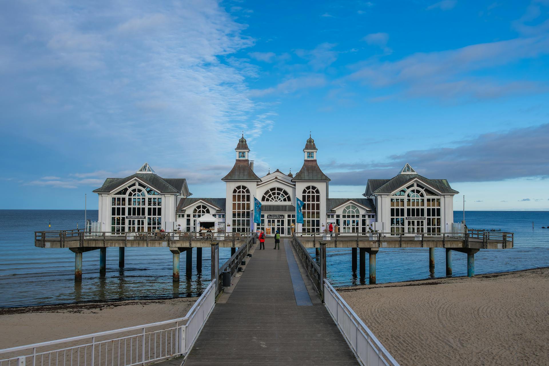 A scenic view of the pier and pavilion on Rügen Island with a clear blue sky backdrop.