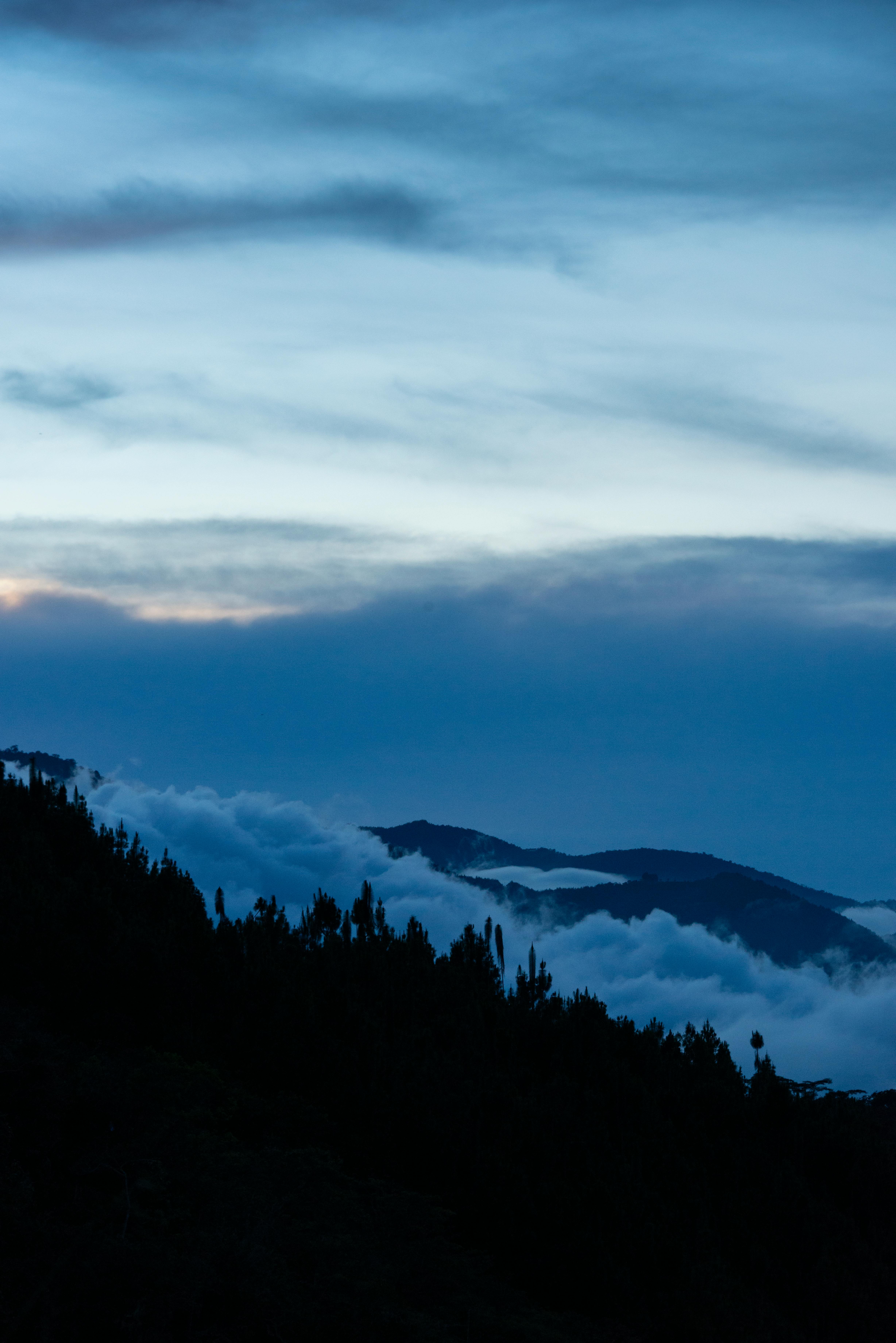 黄昏时分，云雾缭绕的山地景观宁静而优美，非常适合欣赏自然风光