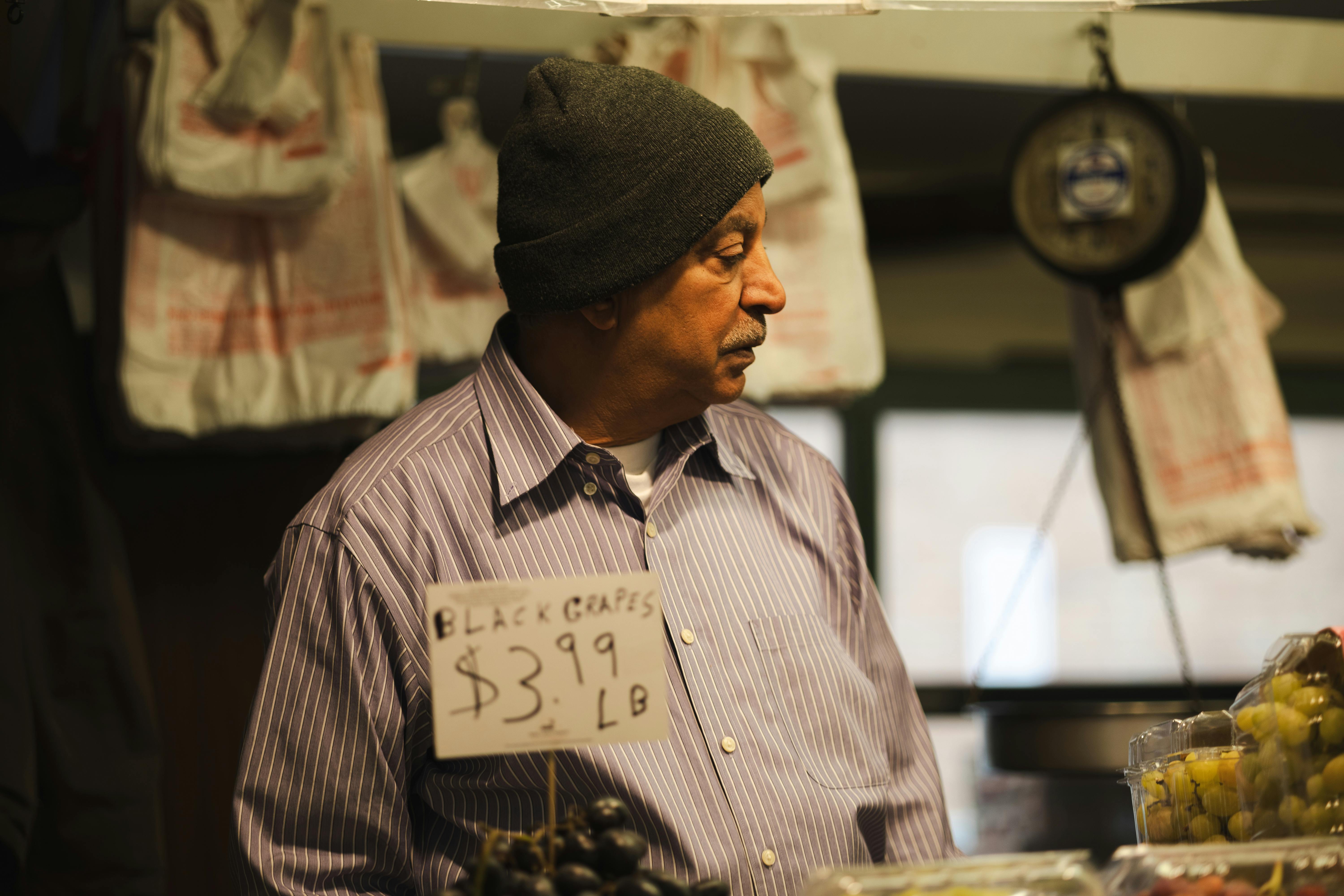 street vendor selling grapes at market stall