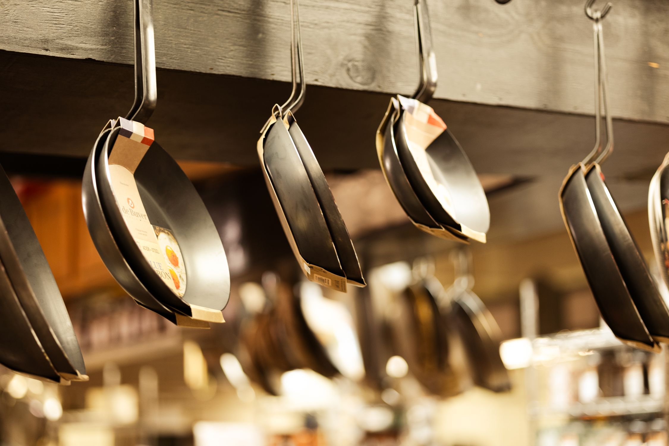 Pan Display Hanging Frying Pans in Kitchen Store Display · Free Stock Photo