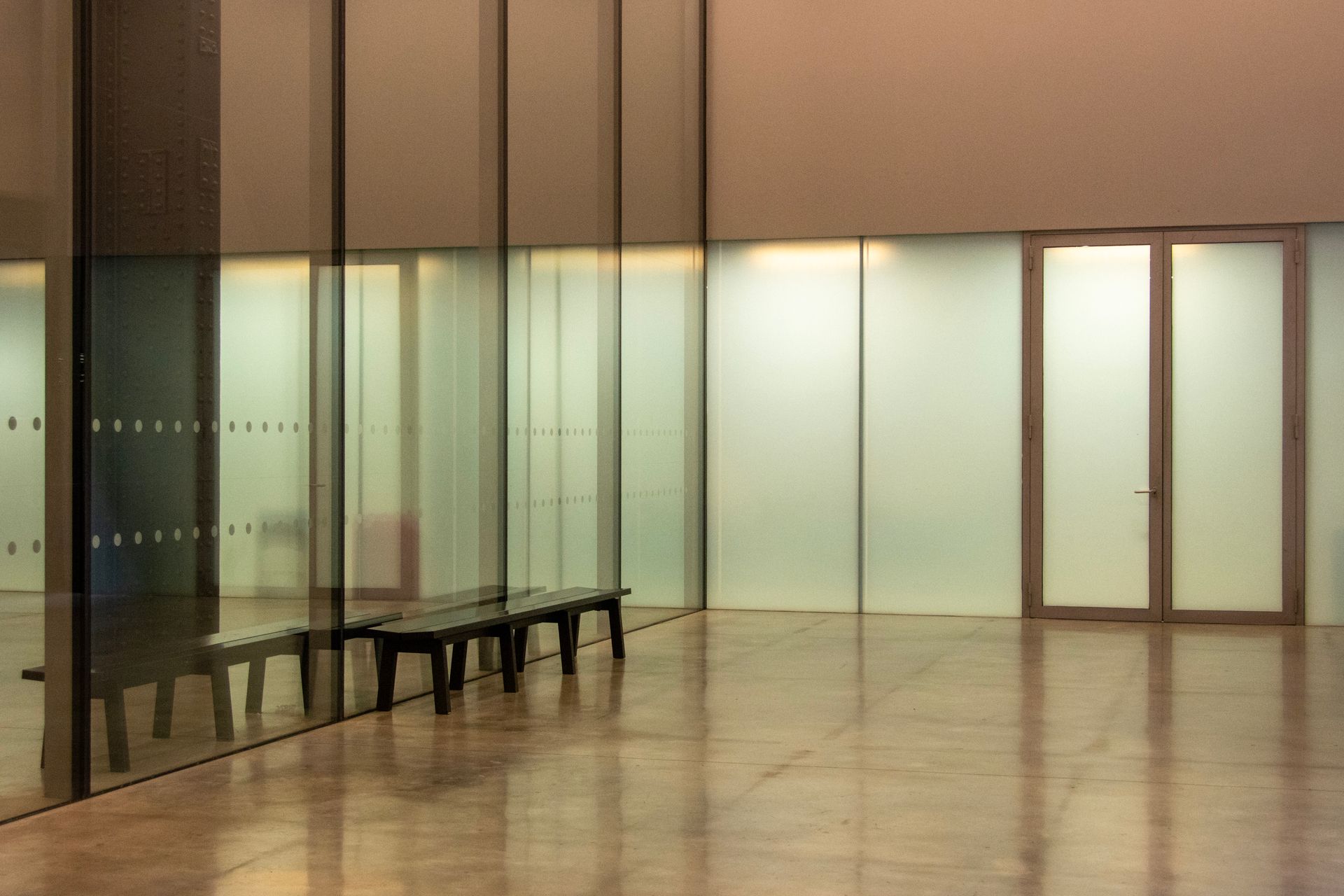 Minimalist interior with reflective surfaces and glass walls offers modern elegance.