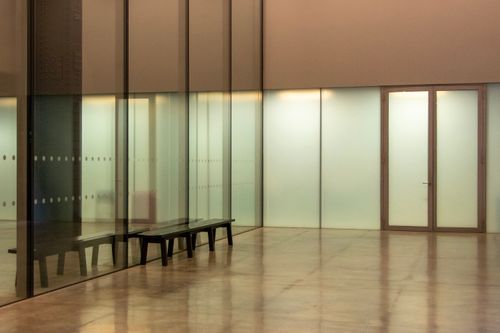 Free Minimalist interior with reflective surfaces and glass walls offers modern elegance. Stock Photo