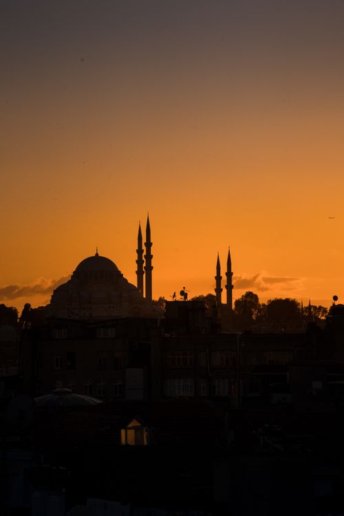 Free A breathtaking silhouette of a mosque against a vibrant orange sunset sky, capturing architectural beauty. Stock Photo