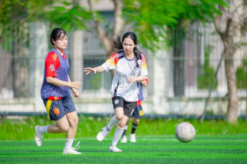 Free Girls playing soccer outdoors in Hà Nội, Vietnam. Captured action. Stock Photo