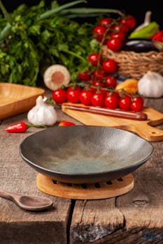 Empty ceramic bowl with fresh vegetables and herbs on rustic table.