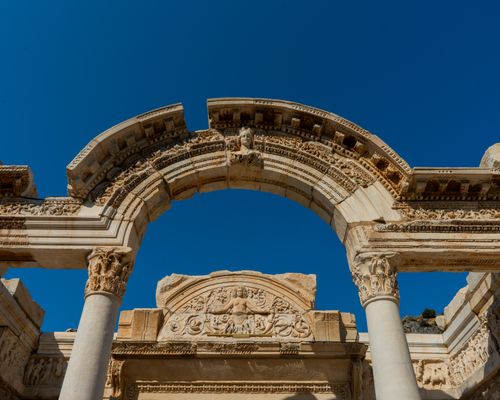 Free Intricate ancient Roman arch in Ephesus, Turkey framed against a clear blue sky. Stock Photo