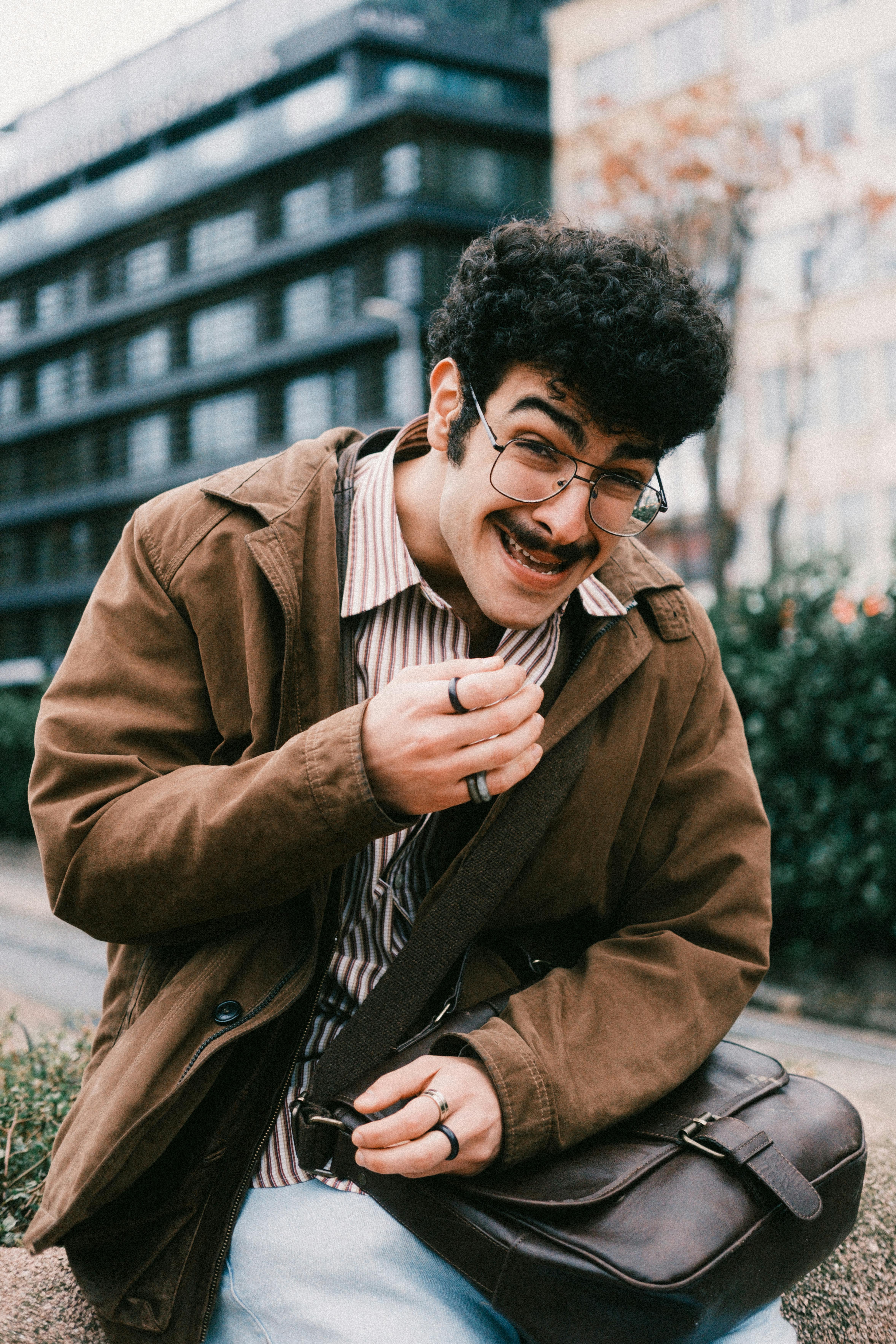 Gratuit Un homme joyeux portant des vêtements de style vintage riant sur fond de ville moderne. Photos