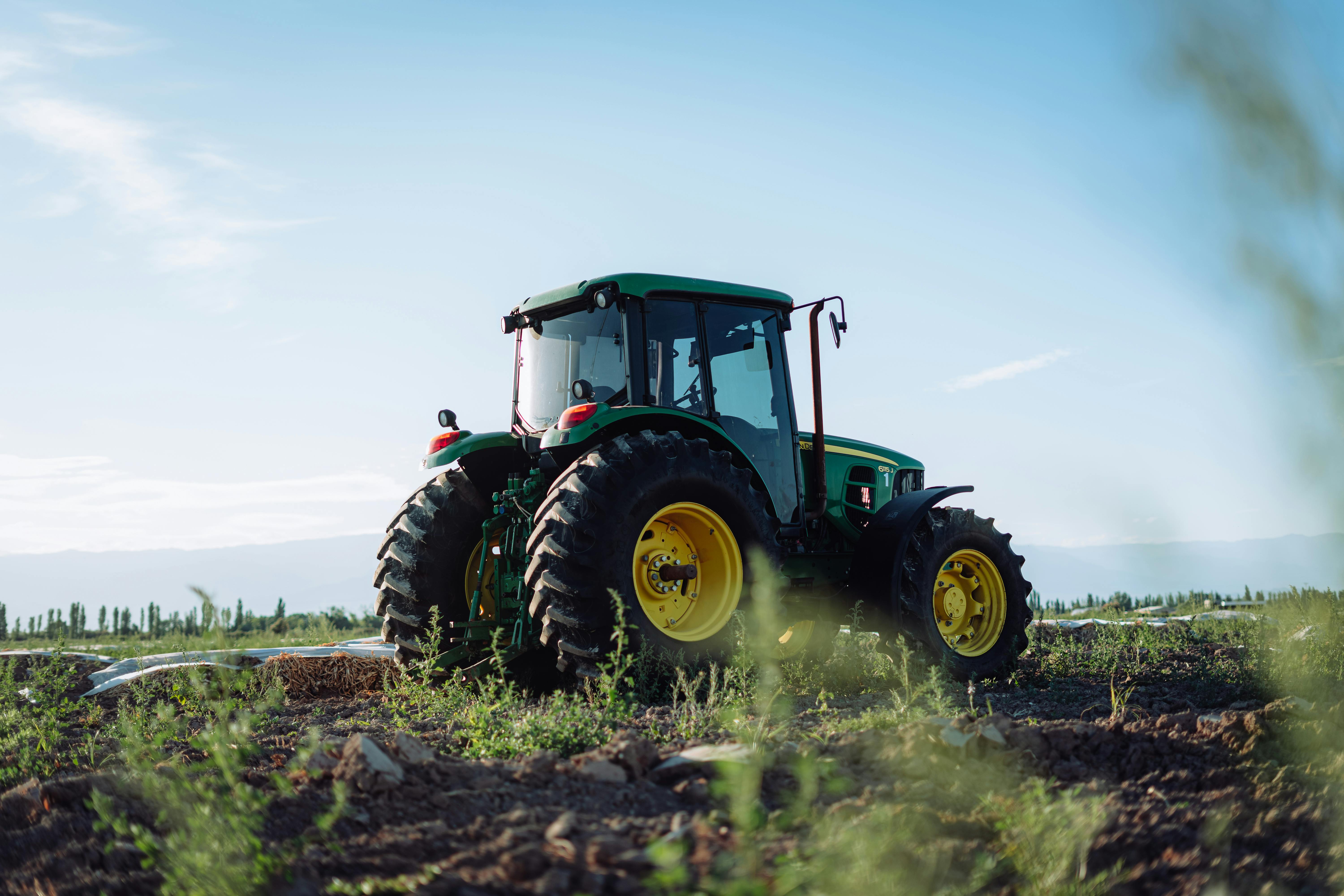 Free A vibrant green tractor on a farm in Mendoza, Argentina, under clear blue skies. Stock Photo