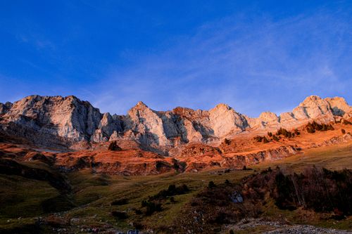 Free Majestic mountain peaks in Walenstadt, Switzerland illuminated by the warm hues of a sunset. Stock Photo