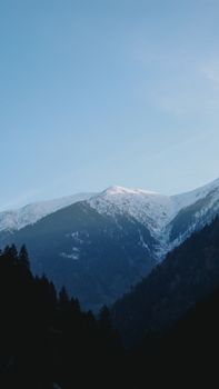 Stunning view of snow-covered mountain peaks during the early hours of the day.