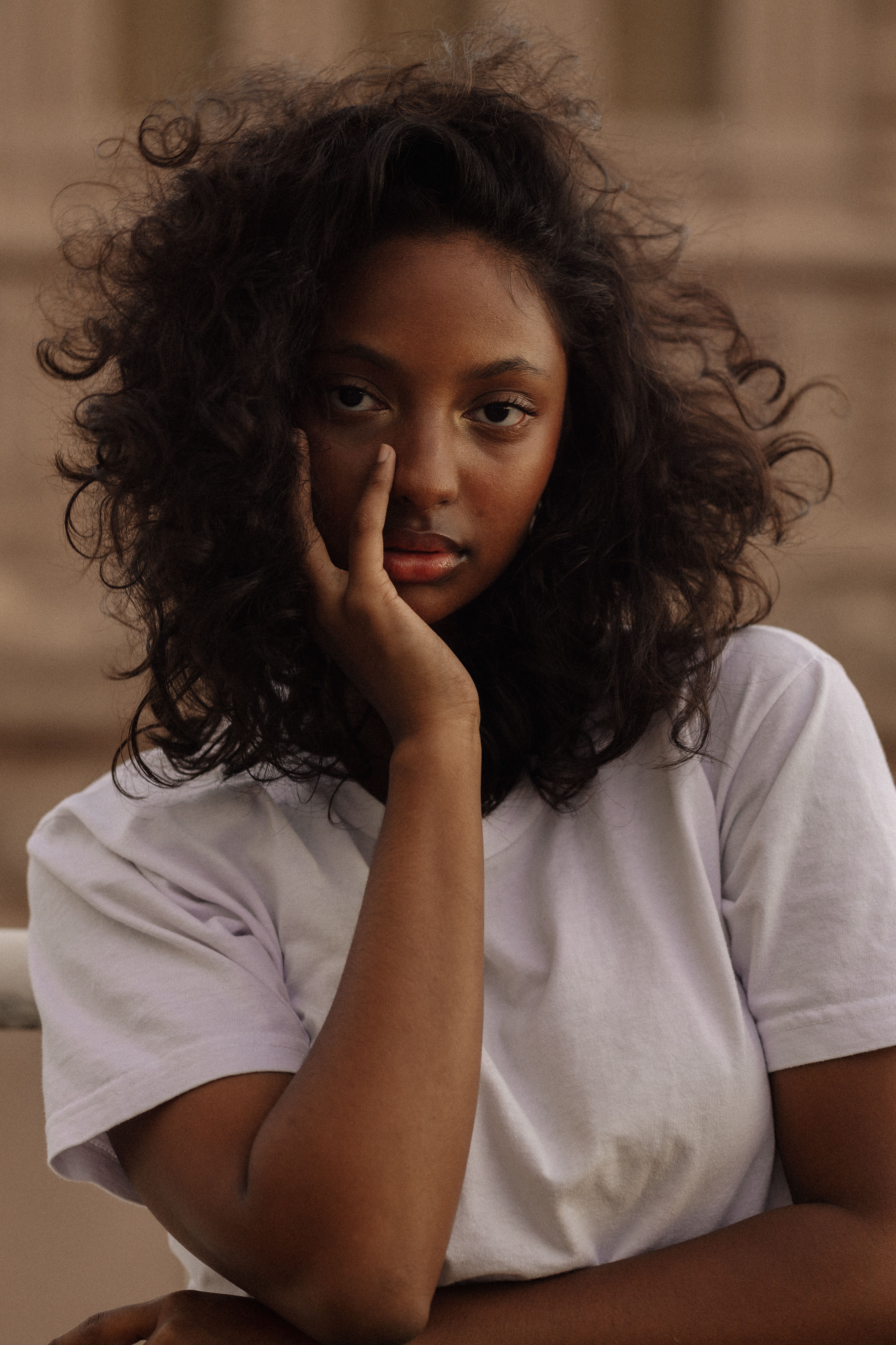 Captivating portrait of a young woman with curly hair and a contemplative expression, taken in Brazil.