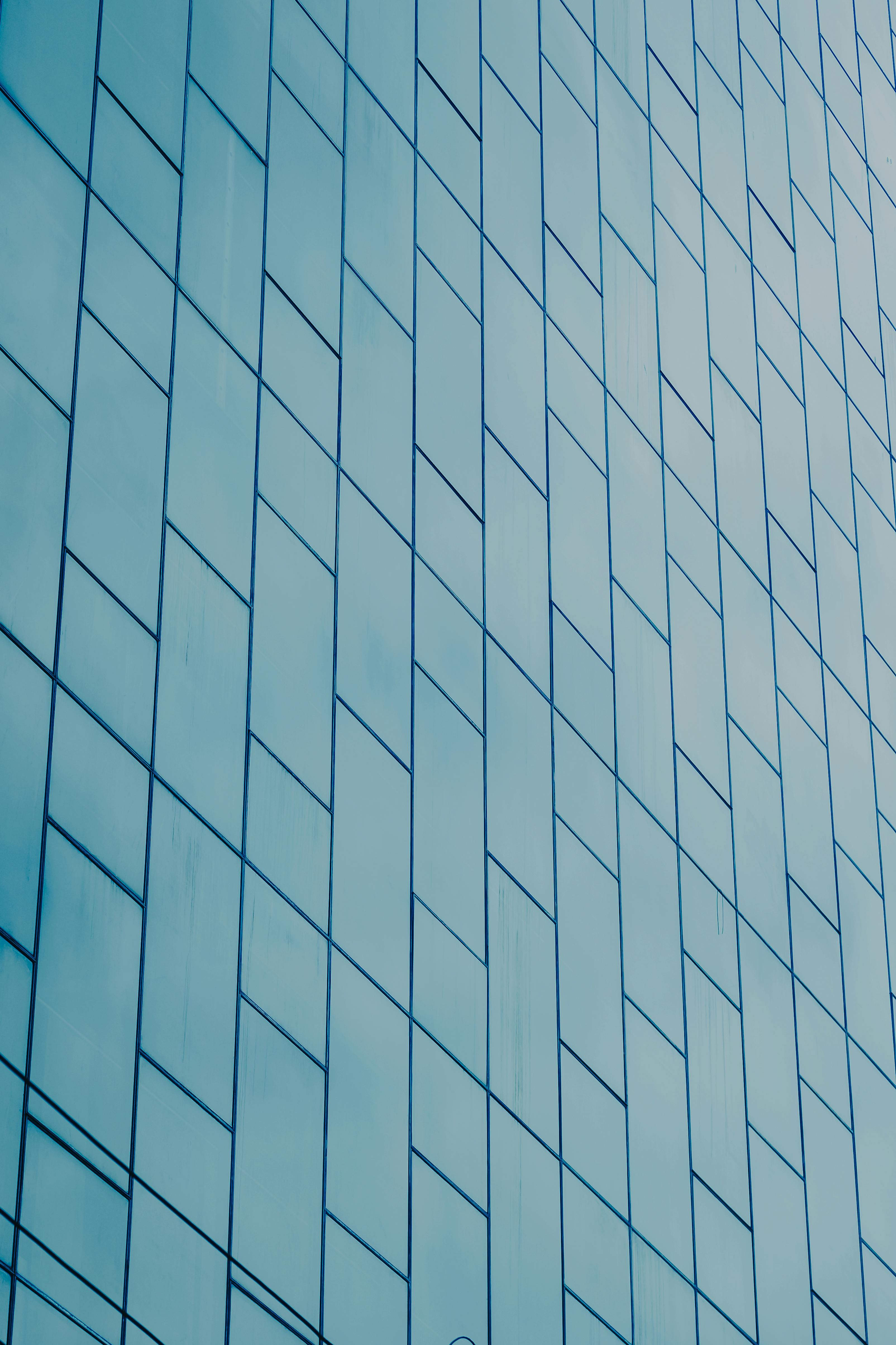 grátis Uma fachada de edifício de vidro moderna com um padrão geométrico distinto em estilo minimalista. Foto profissional