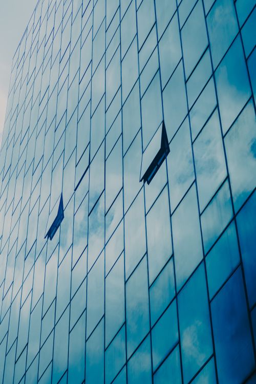 Free Skyscraper facade reflecting clouds with open windows, showcasing modern architecture. Stock Photo