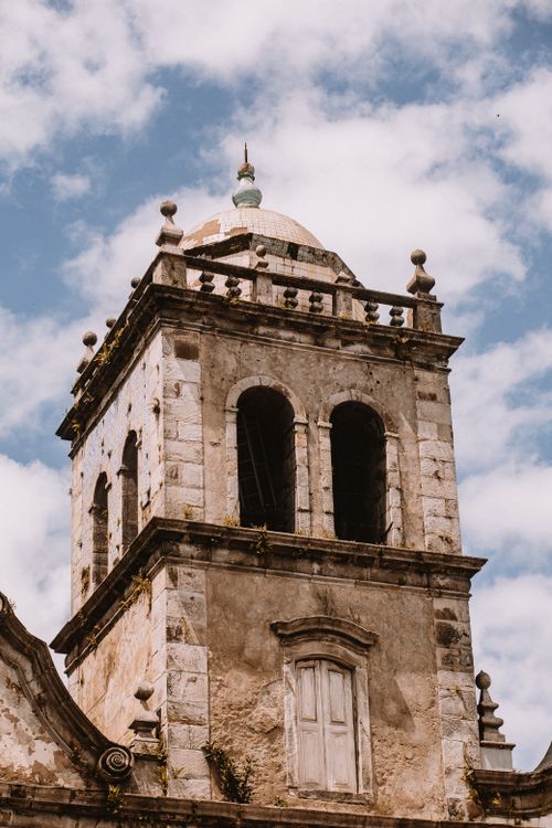 Free Old stone bell tower with ornate architectural details against a bright blue sky. Stock Photo