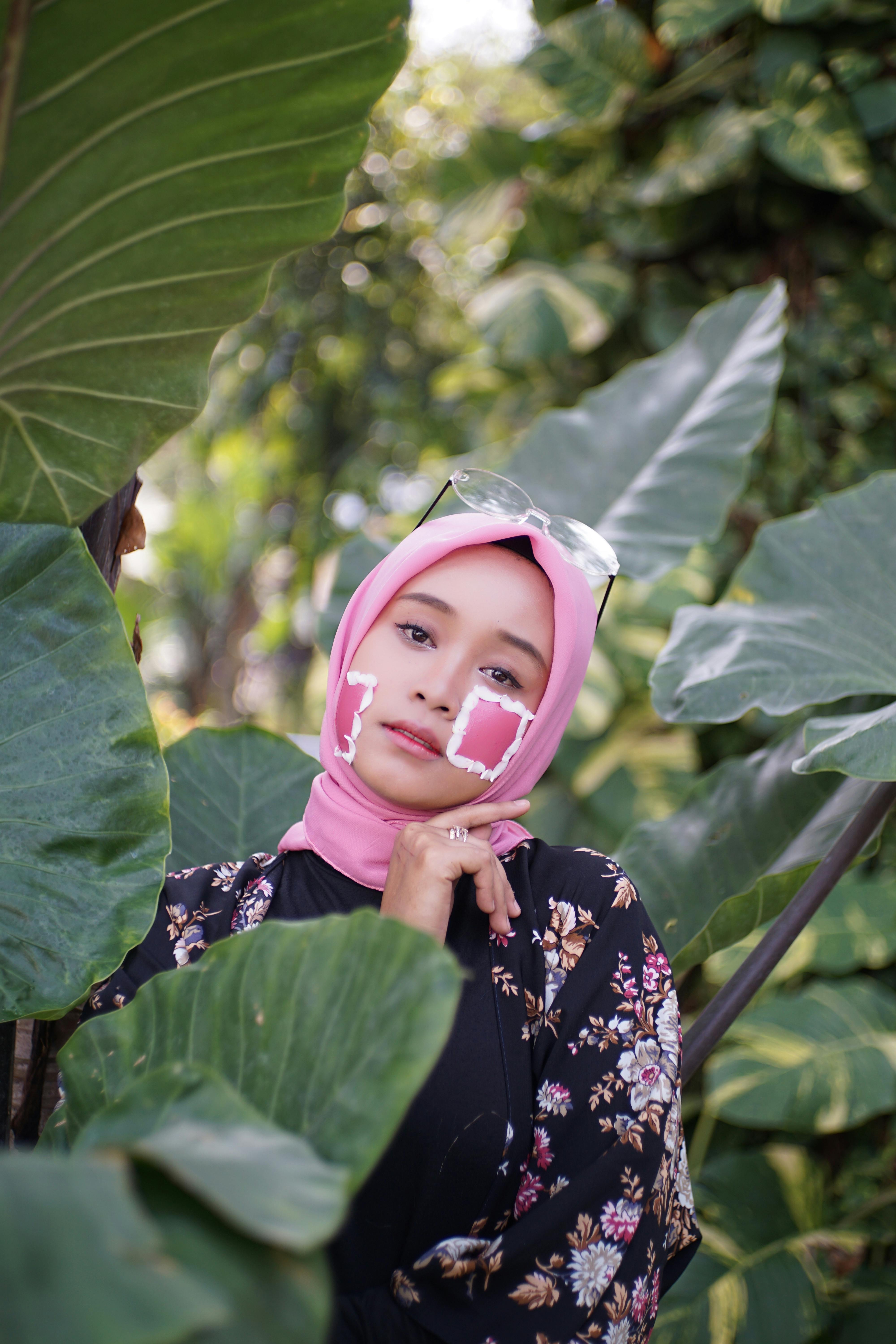 photo-of-woman-in-pink-hijab-posing-by-green-taro-plants-free-stock-photo