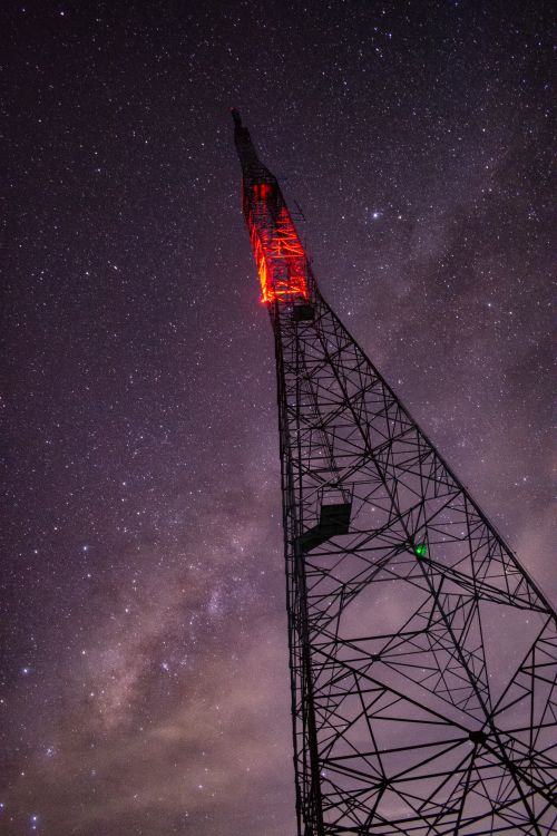Free A communication tower illuminated against a starry night sky. Stock Photo