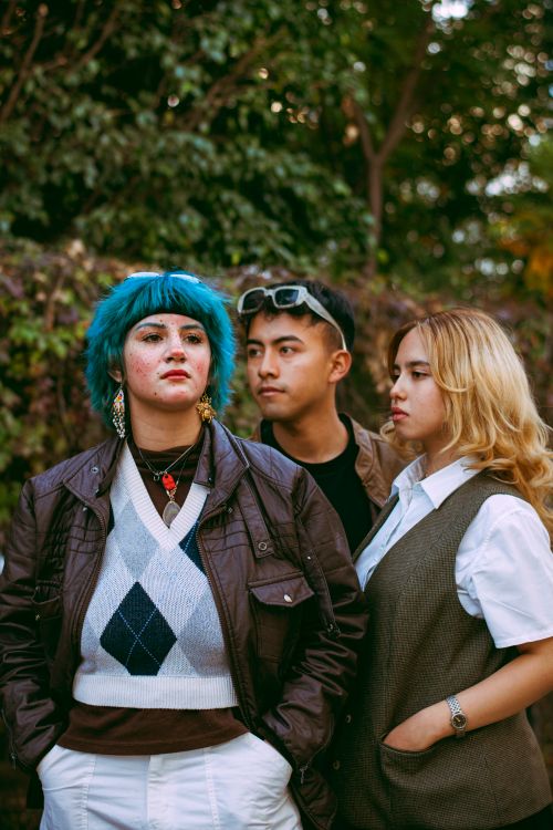 Free Group of stylish young adults in urban setting, exploring fashion trends. Stock Photo