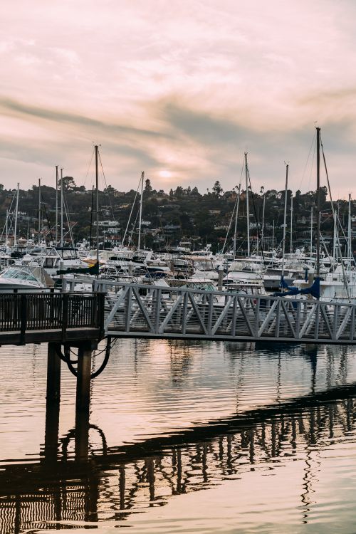 Free A tranquil harbor filled with boats and yachts under a beautiful sunset sky. Stock Photo