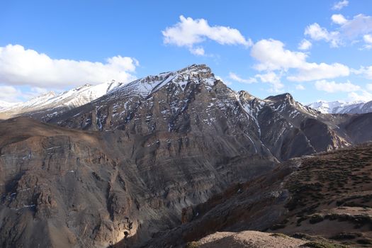 Breathtaking view of the rugged snow-capped mountains in Ladakh, India against a clear blue sky.