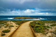 壮观的云层下，木制木板路通向令人惊叹的海景