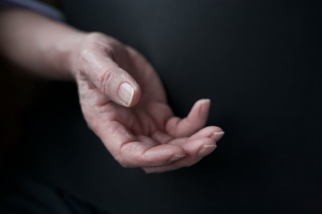 A close-up of an elderly hand, showcasing intricate details and textures, emphasizing age and experience.