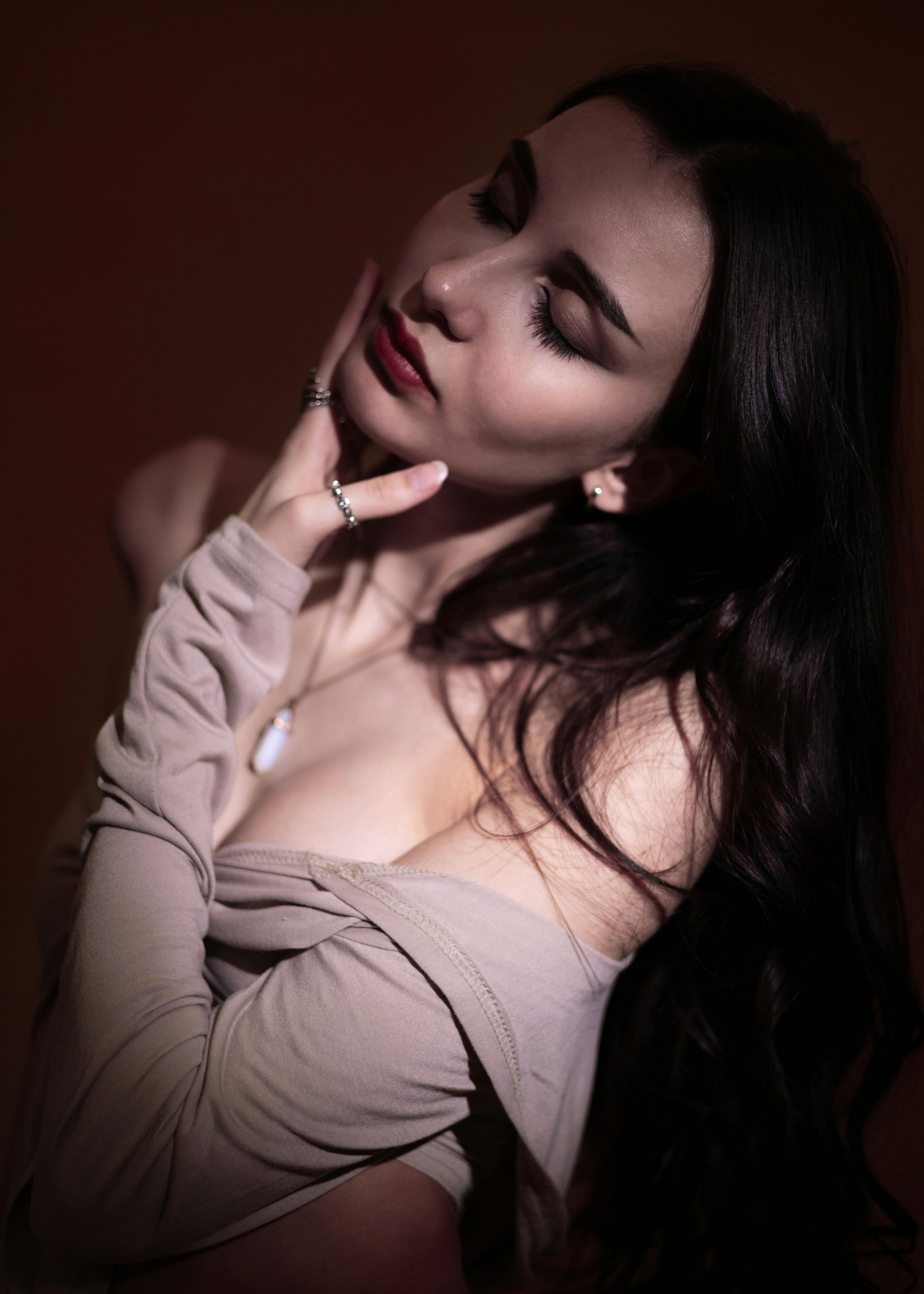 Elegant woman with eyes gently closed, bathed in soft warm light, serene and surrendered