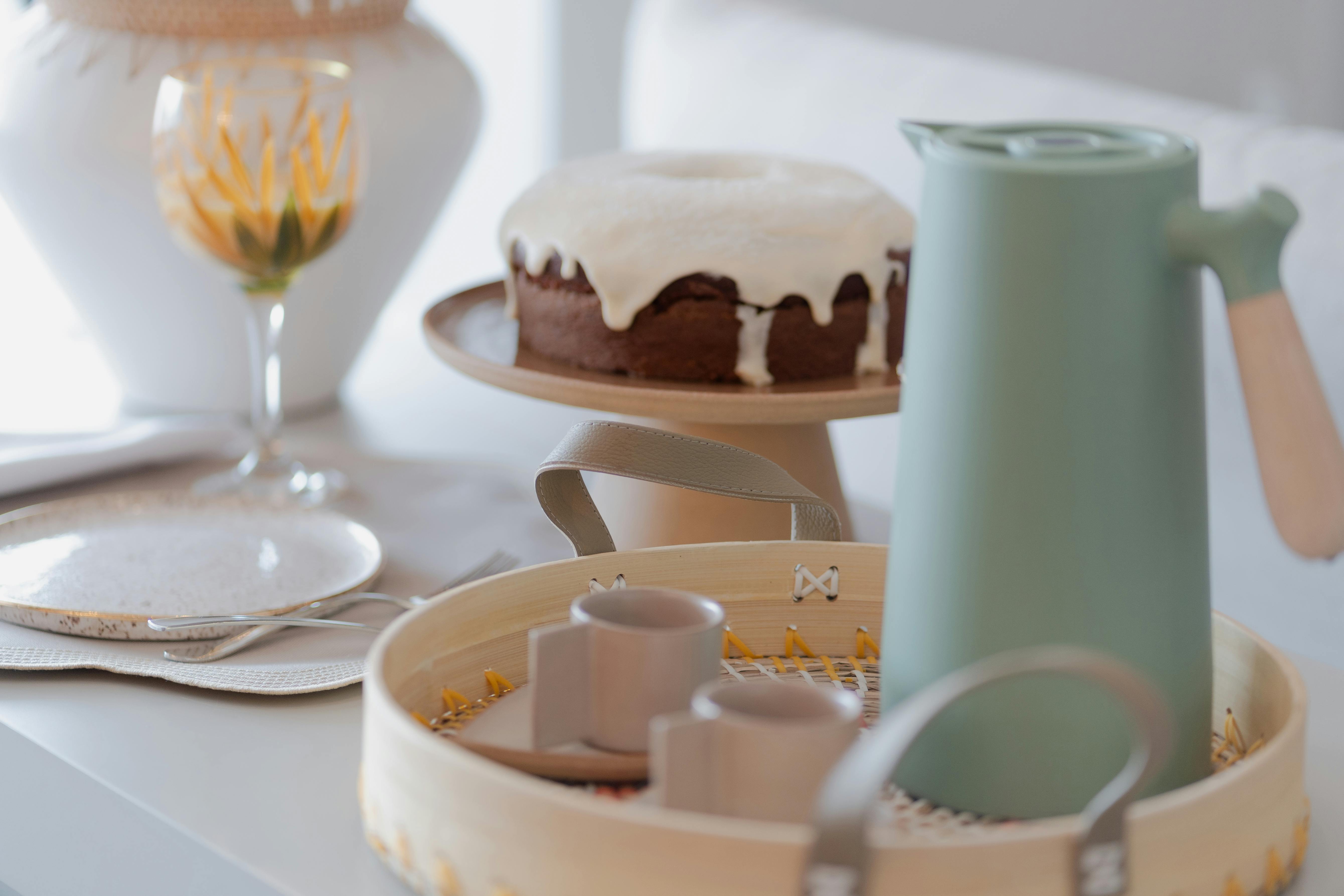 A cozy breakfast setting featuring coffee, cake, and elegant dishware in natural tones.