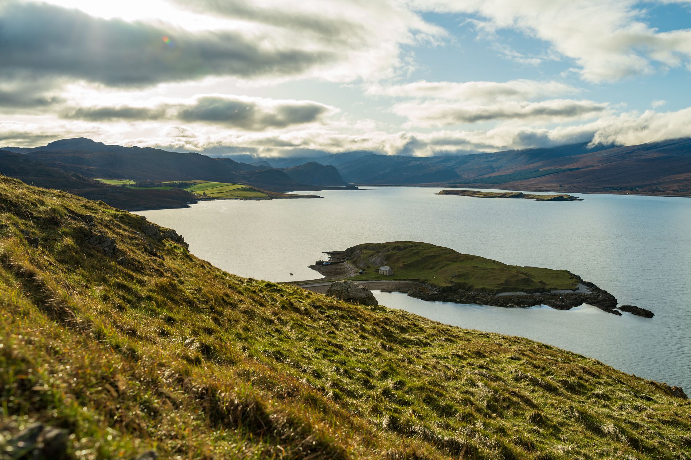 Stunning view of a rugged coastline with a serene ocean under a cloudy sky.