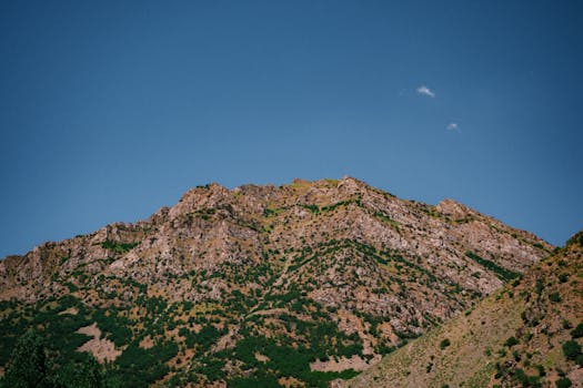 A breathtaking view of a rocky mountain range against a clear blue sky, showcasing nature's beauty.