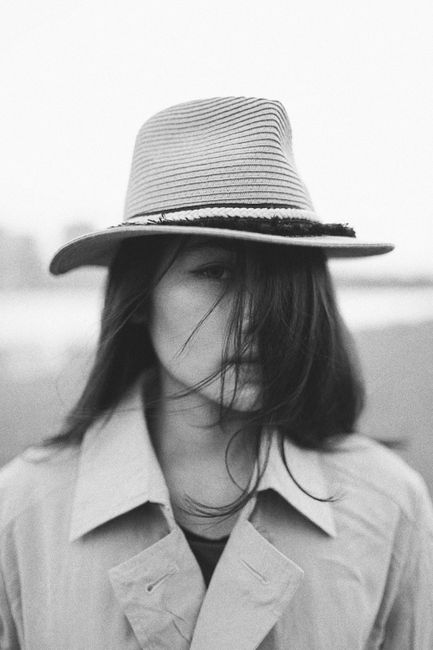 Elegant black and white portrait of a woman wearing a fedora, exuding style and mystery.