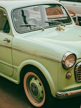 Close-up of a mint-green vintage car, showcasing classic curves and design.