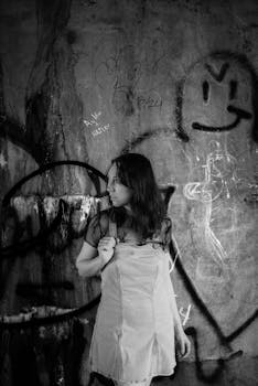 A creative monochromatic portrait featuring a woman against an urban graffiti backdrop, highlighting street art.