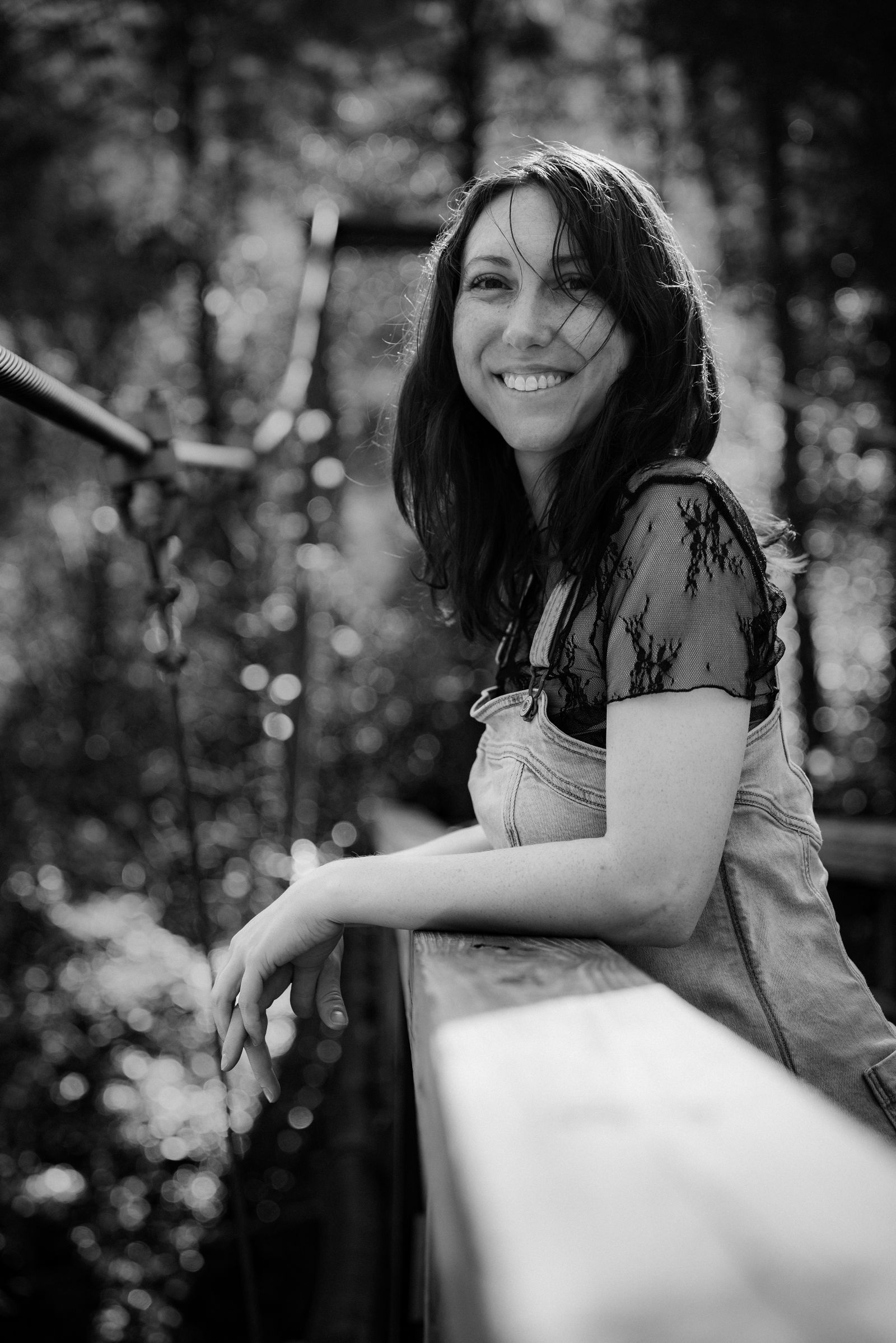 Smiling Woman on a Bridge in Sunlit Forest · Free Stock Photo