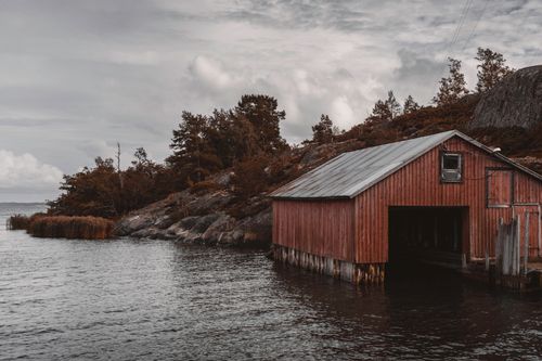 Free Rustic boathouse on the Åland Islands, surrounded by serene waters and nature. Stock Photo